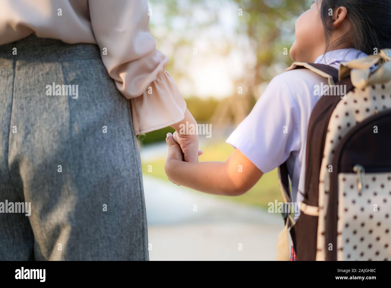 Nahaufnahme der Glücklichen asiatischen Mutter und Tochter im Vorschulalter Schüler zu Fuß zur Schule. Beginn der Unterrichtsstunden. Erster Tag der Fall. Elternschaft oder Liebe und Bondi Stockfoto