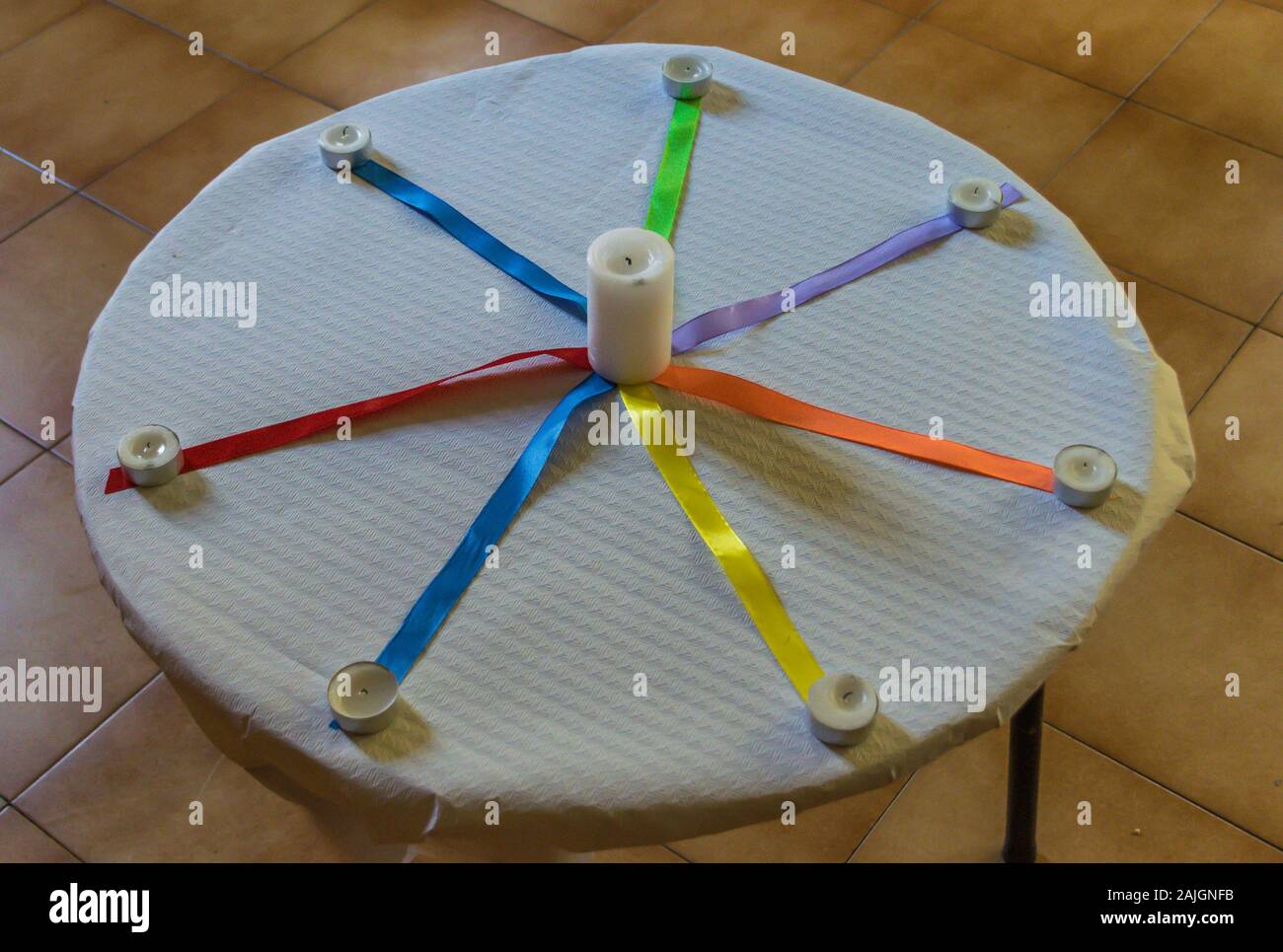 Kerzen aus, mit farbigen Kabelbindern auf einem Tisch mit weißer Tischdecke Papier Stockfoto