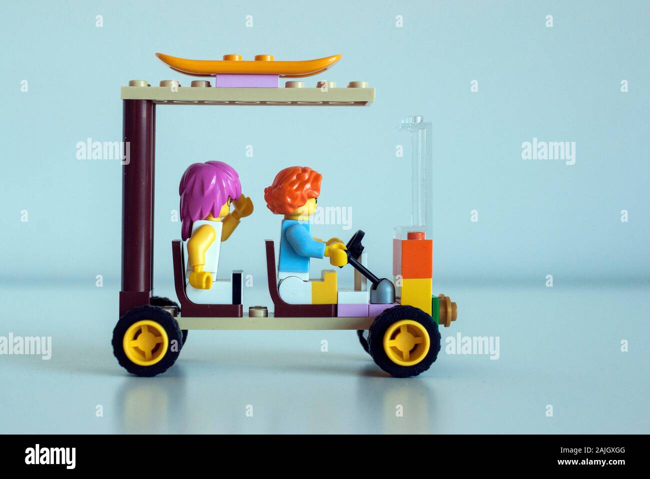 Lego Figuren fahren an der Küste in einem Auto mit einem Surfbrett auf der Oberseite Stockfoto