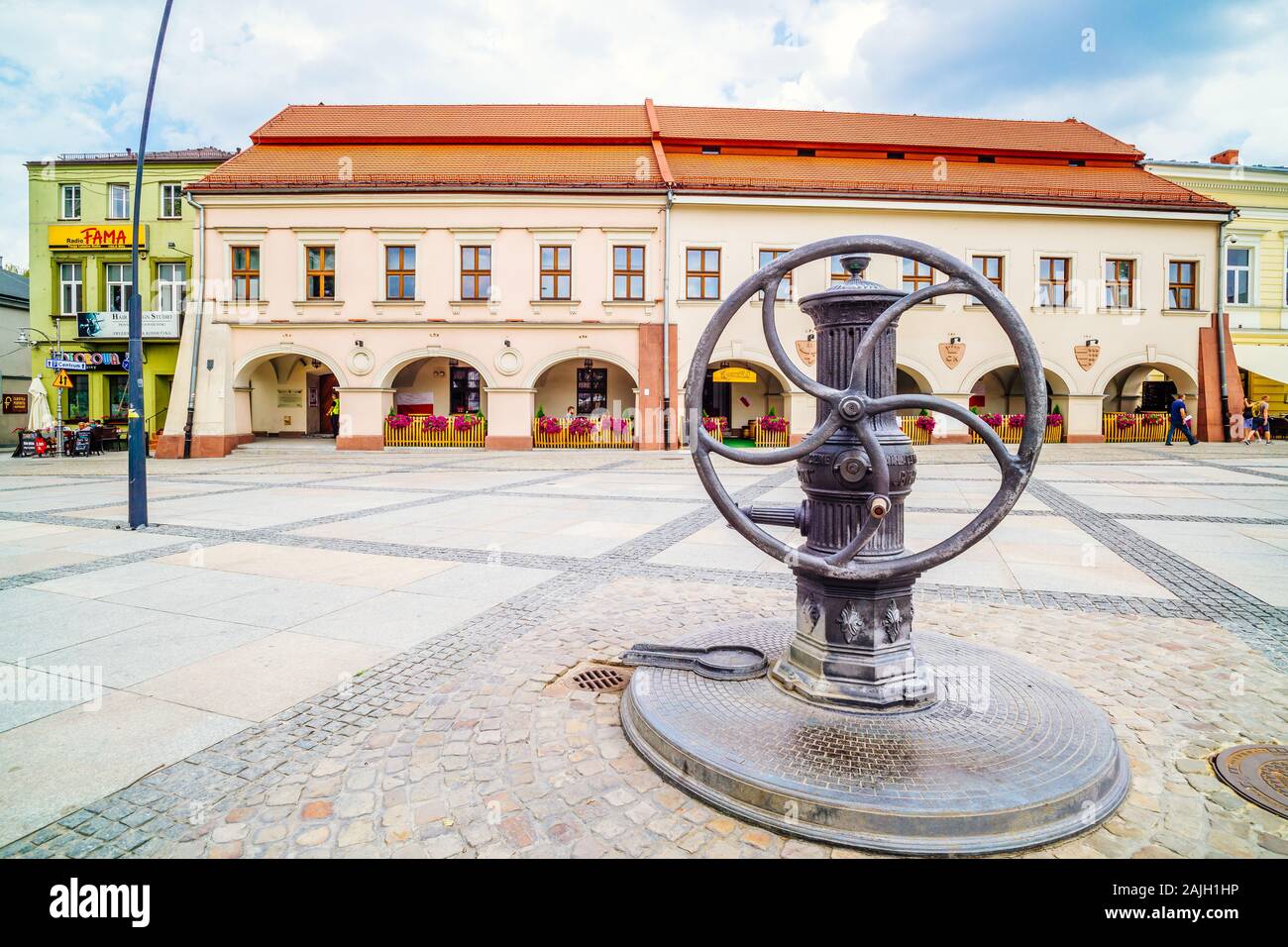 , Swietokrzyskie in Kielce, Polen, Juni 2016 Vintage Wasserpumpe mit Rad am Marktplatz. Museum der Dialog der Kulturen in den Hintergrund Stockfoto