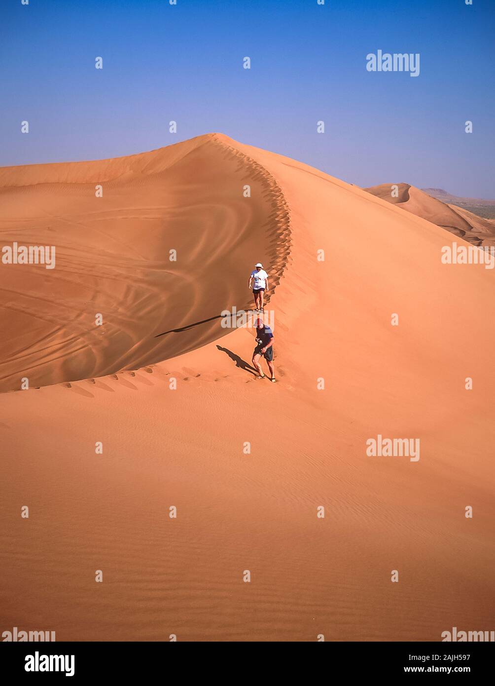 Dubai. Die europäischen Touristen genießen die wunderschöne Wüstenlandschaft von natürlichen, von Wind verwehten Sanddünen in der Nähe des Dorfes Al Dhaid am Straßenrand zwischen der Stadt Dubai und der ländlichen Festung Oasis Hatta Stockfoto