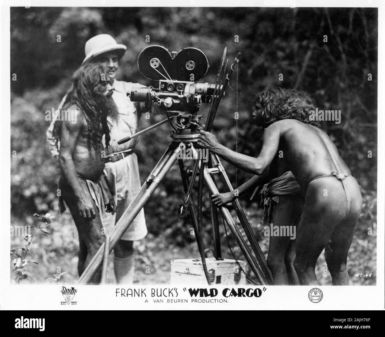 FRANK BUCK offen mit zwei native Stammesangehörigen auf Film Kamera schaut während der Dreharbeiten von WILDEN CARGO 1934 Regisseur Armand Denis Van Beuren Studios/RKO Radio Pictures Stockfoto