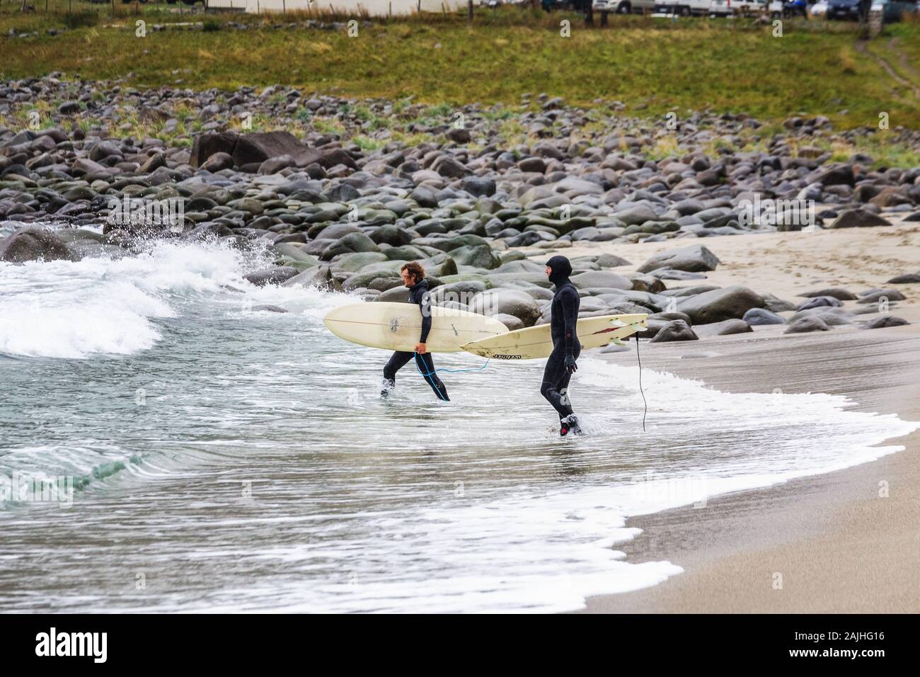 Arktis Surfer Surfen in der Norwegischen See. Unstad, Norwegischen Dorf auf der Lofoten. Norwegische Küste. Winter Wasser Sport. Uttakle Stockfoto