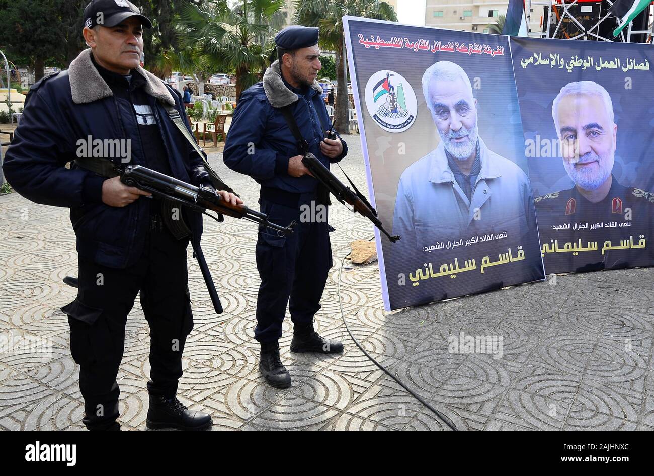 In Gaza. Am 4. Januar, 2020. Palästinensischen Polizisten stand Guard neben Bildern der älteren Iranischen commander Qasem Soleimani während einer Trauer Zeremonie in Gaza Stadt, Jan. 4, 2020 statt. Credit: Abdeljawad Rizek/Xinhua/Alamy leben Nachrichten Stockfoto