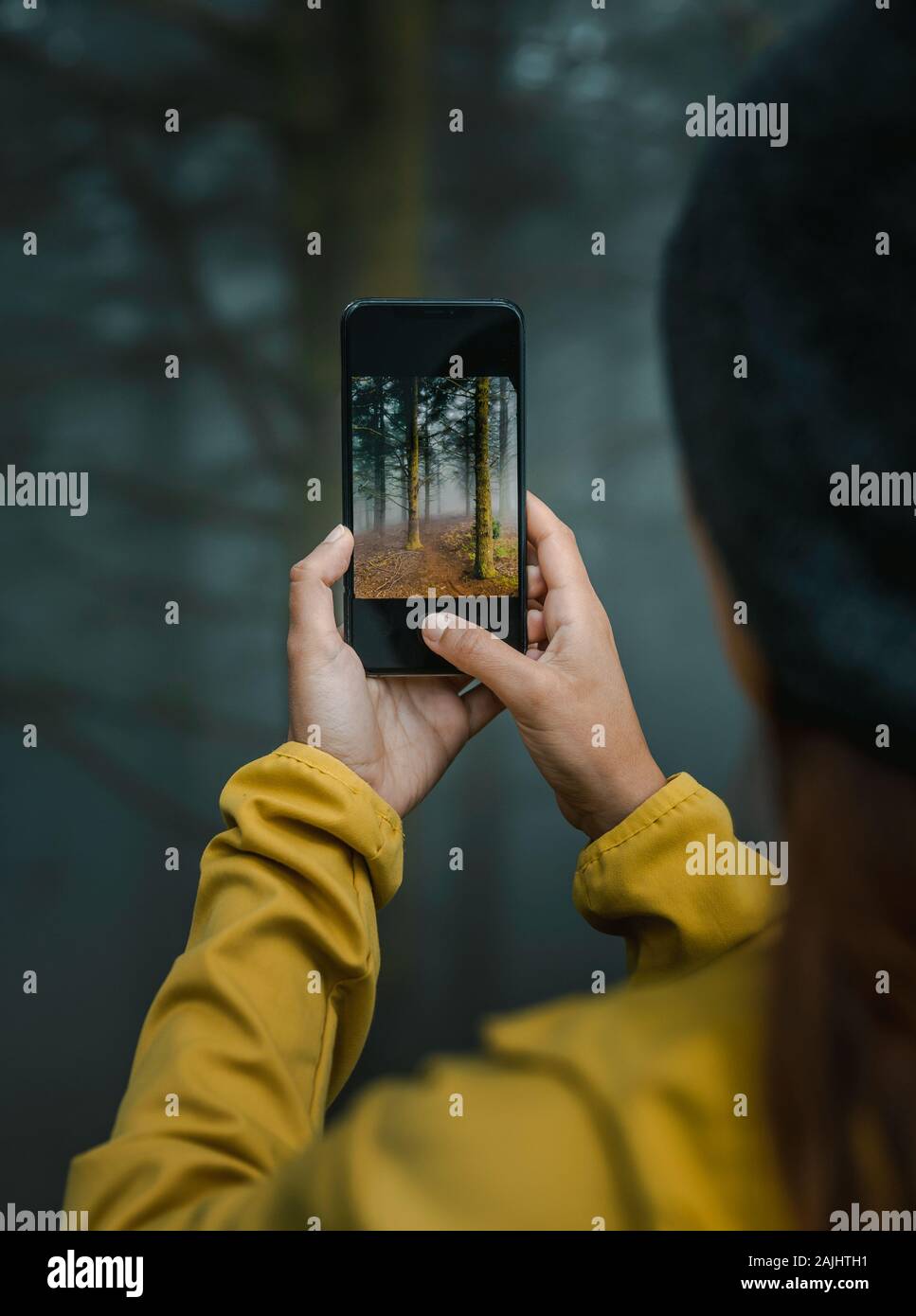 Weibliche Reisende sich ein Bild an einen Wald mit Ihrem Handy Stockfoto