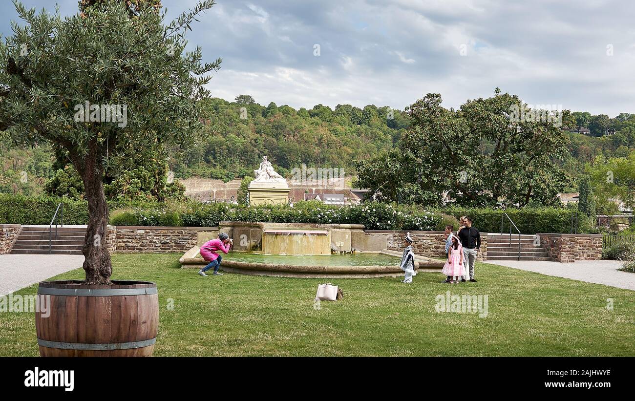 Die Fotografin nimmt eine ethnische Familienfeier mit Eltern und Kindern auf, die sich alle in feierlichen Outfits in Deutschland in der Nähe des Rheins kleiden. Stockfoto