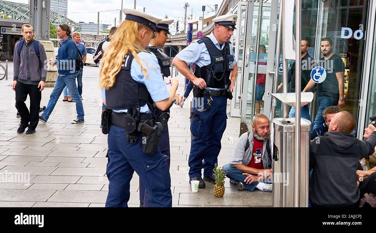 Drei deutsche Polizisten Frage einige Straße Menschen außerhalb der berühmte Kölner Dom Bahnhof. Stockfoto