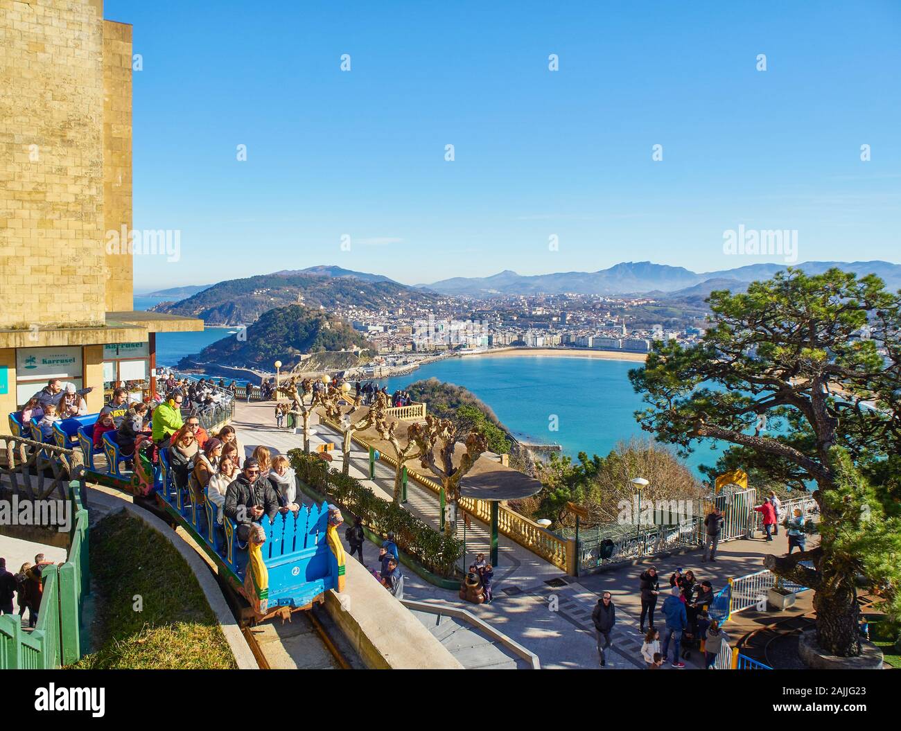 Touristen auf die Achterbahn des Monte Igueldo Vergnügungspark mit der Concha Bucht von San Sebastian im Hintergrund, Baskenland, Spanien. Stockfoto