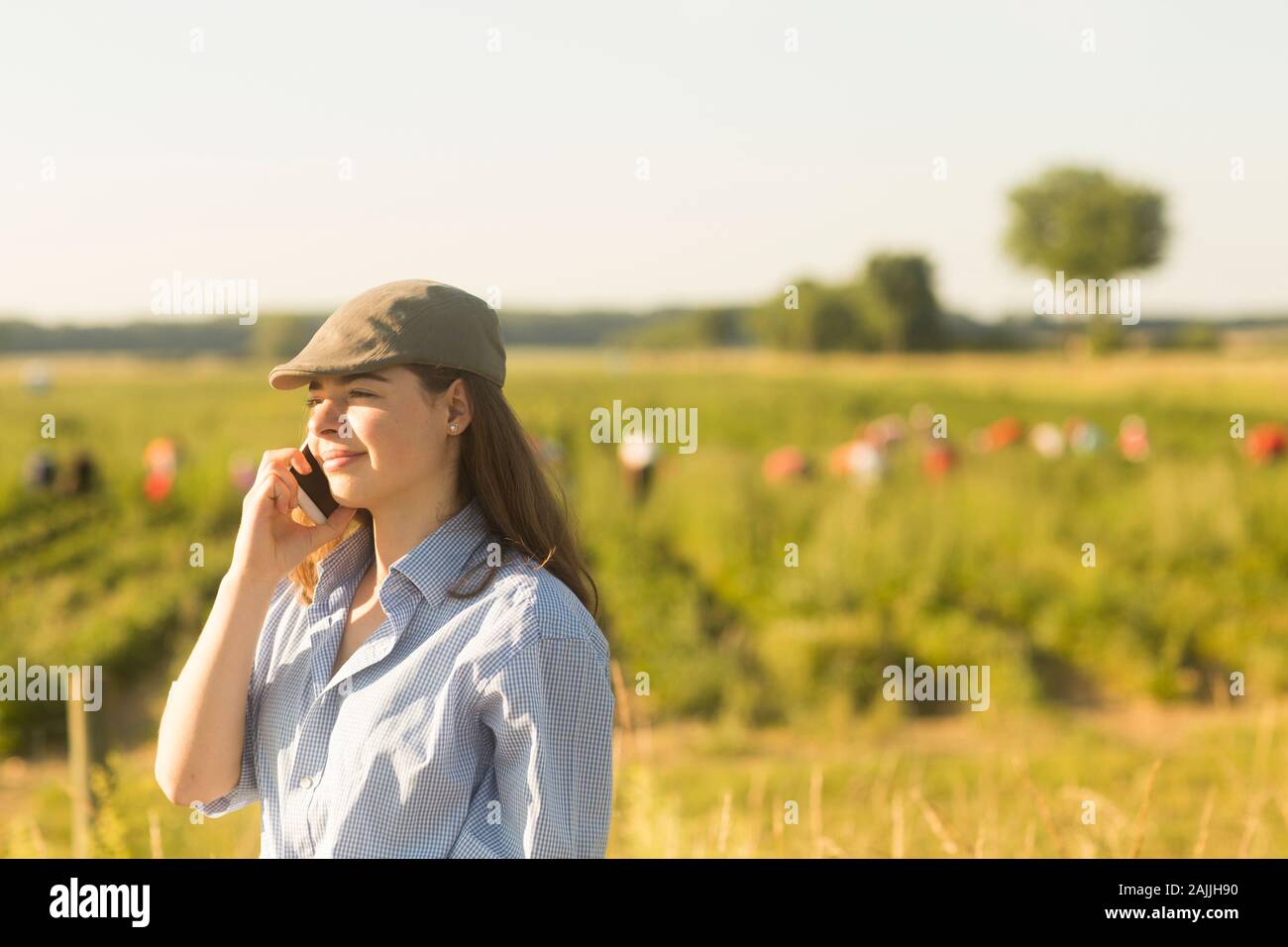 Bäuerin mit Smartphone vor einem Feld Stockfoto