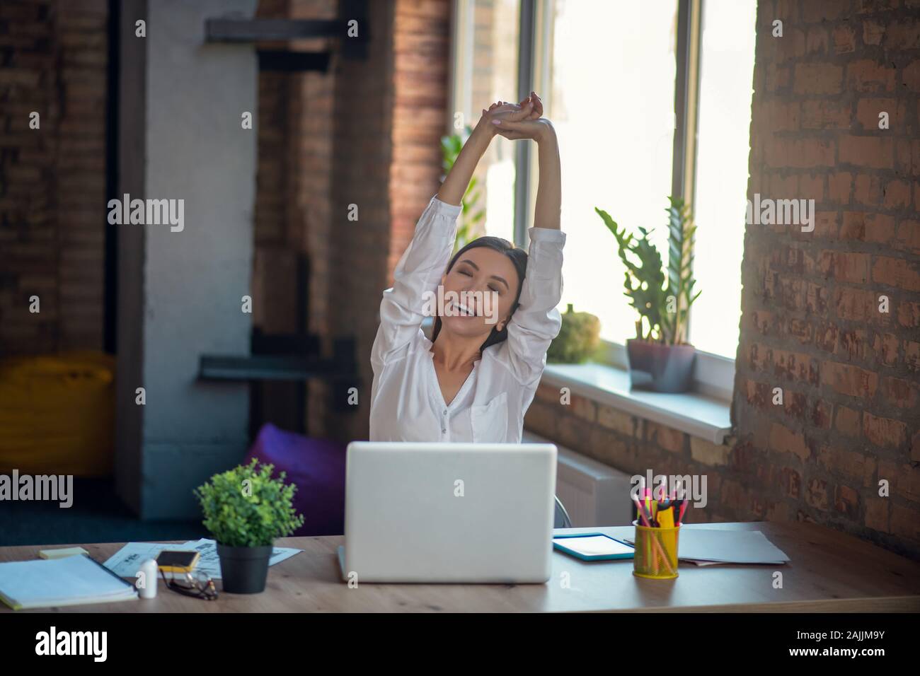 Nette gut aussehende junge Frau selbst Dehnen Stockfoto