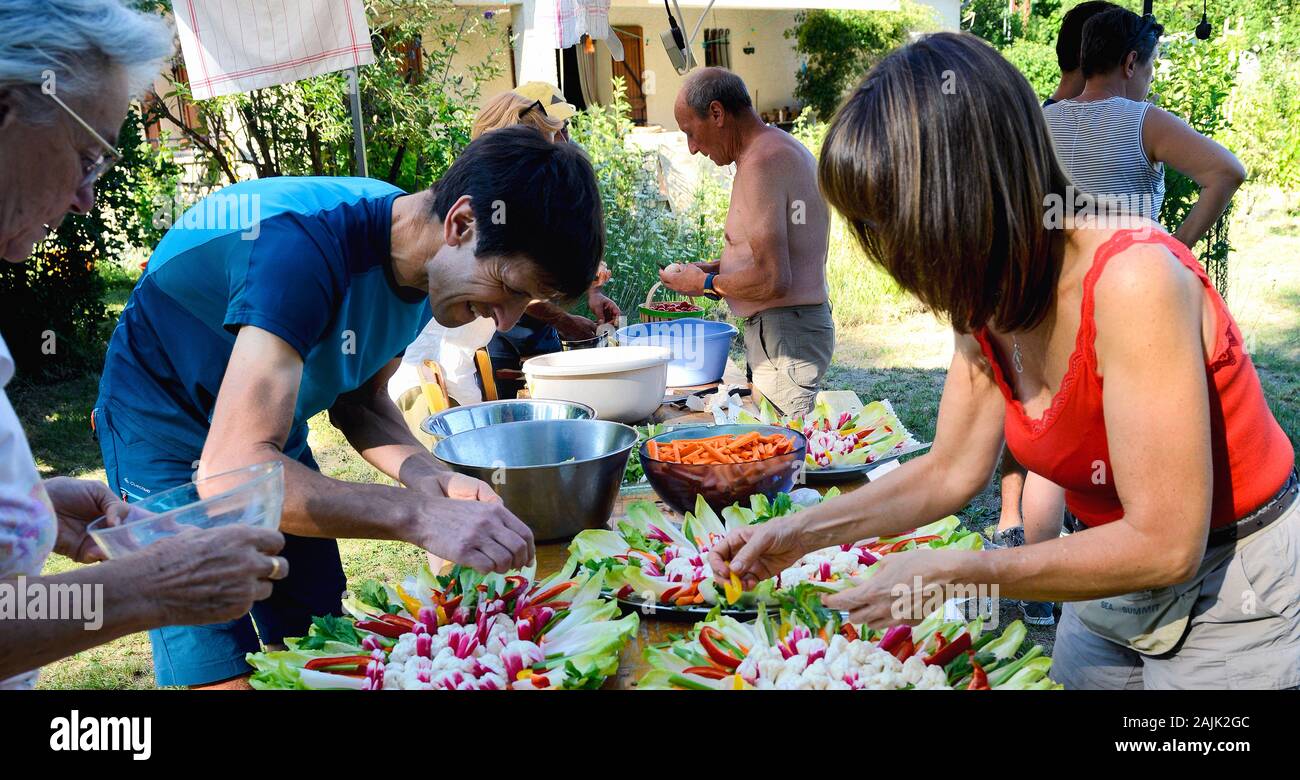 Familie Mitglieder vorbereiten Salate zum Feiern. Provence Frankreich August Stockfoto
