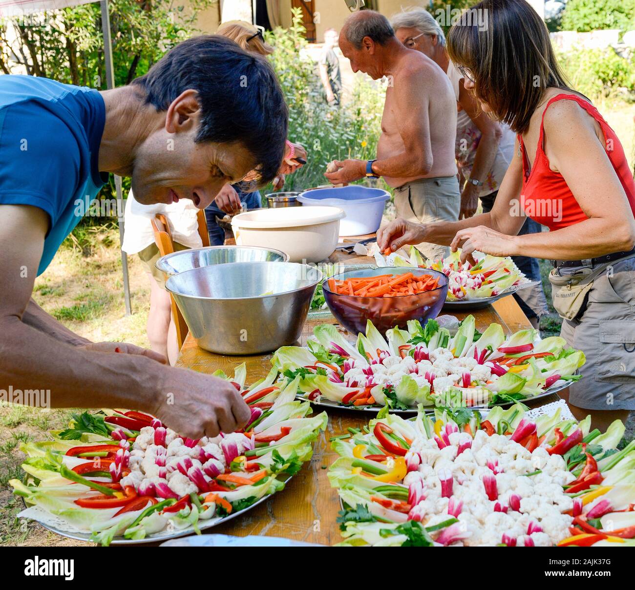 Familie Mitglieder vorbereiten Salate zum Feiern. Provence Frankreich August Stockfoto