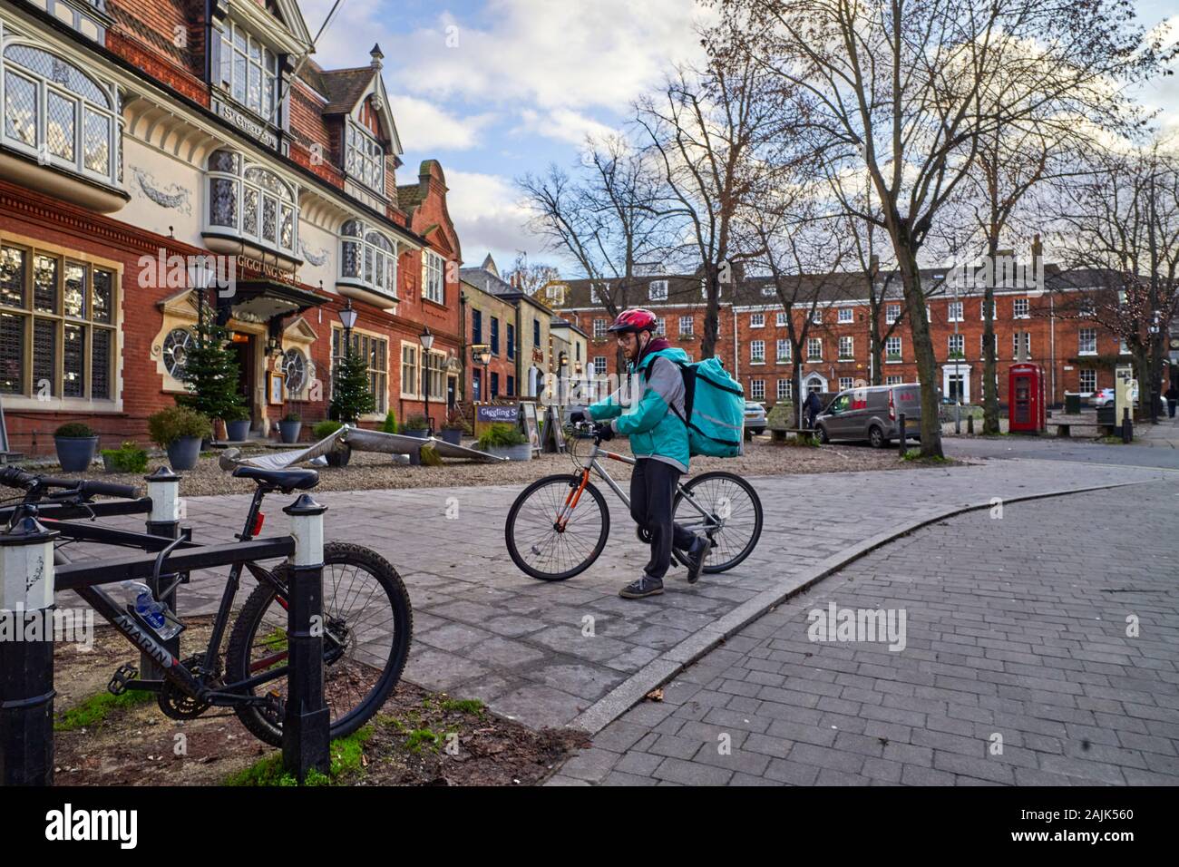 Eine Deliveroo Fahrradfahrerin Tragen eines Fahrradhelme in Norwich Stockfoto