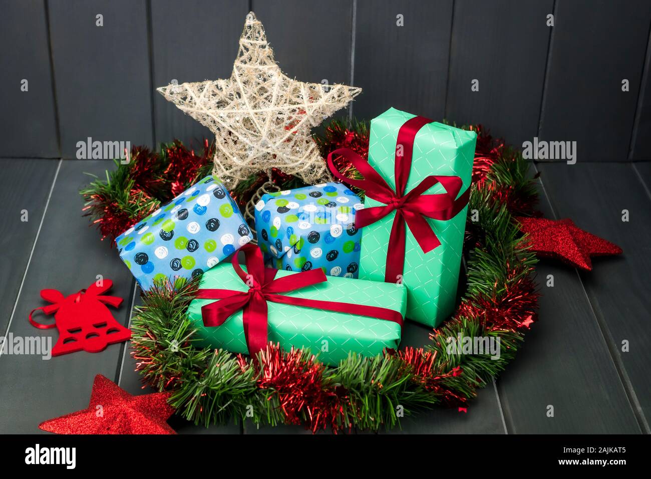 Weihnachten Geschenke verpackt und mit Geschenkpapier und Tuch Krawatten, grüne und rote Lametta und Gold Star auf dunklem Hintergrund Stockfoto