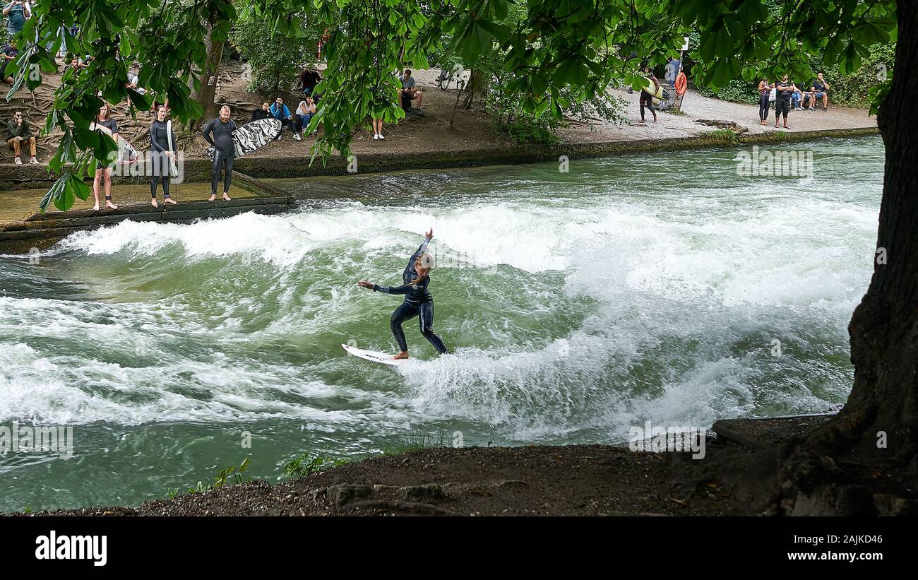 Weibliche Surfer geht auf die Welle im Englischen Garten im städtischen Gegewisse Münchens. Stockfoto