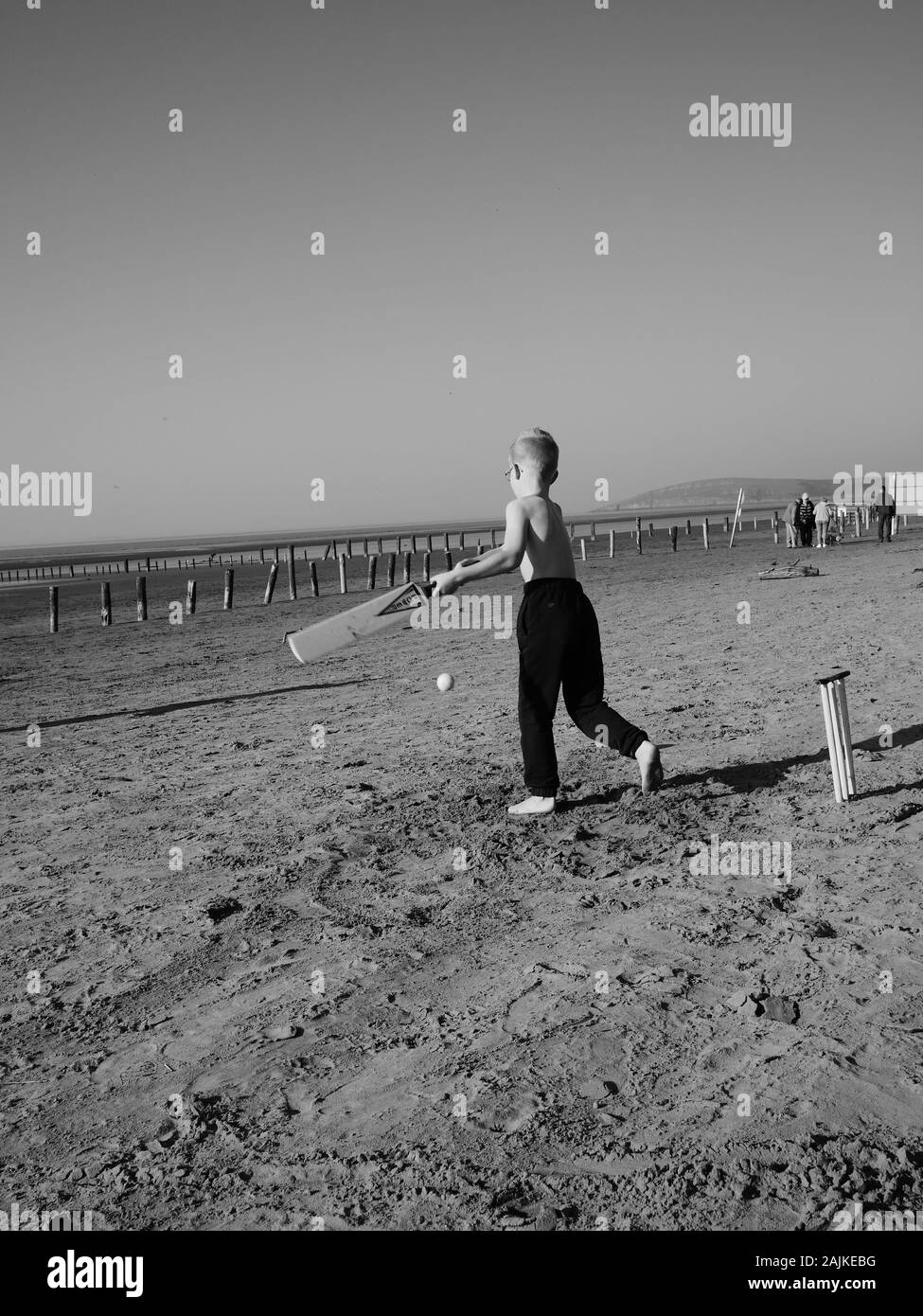 Rekordverdächtige Temperaturen für den 26. Februar 2019. Eine Familie und genießen Sie Kricket spielen in der rekordverdächtige Winter Sonnenschein. Berrow Strand Somerset UK Stockfoto