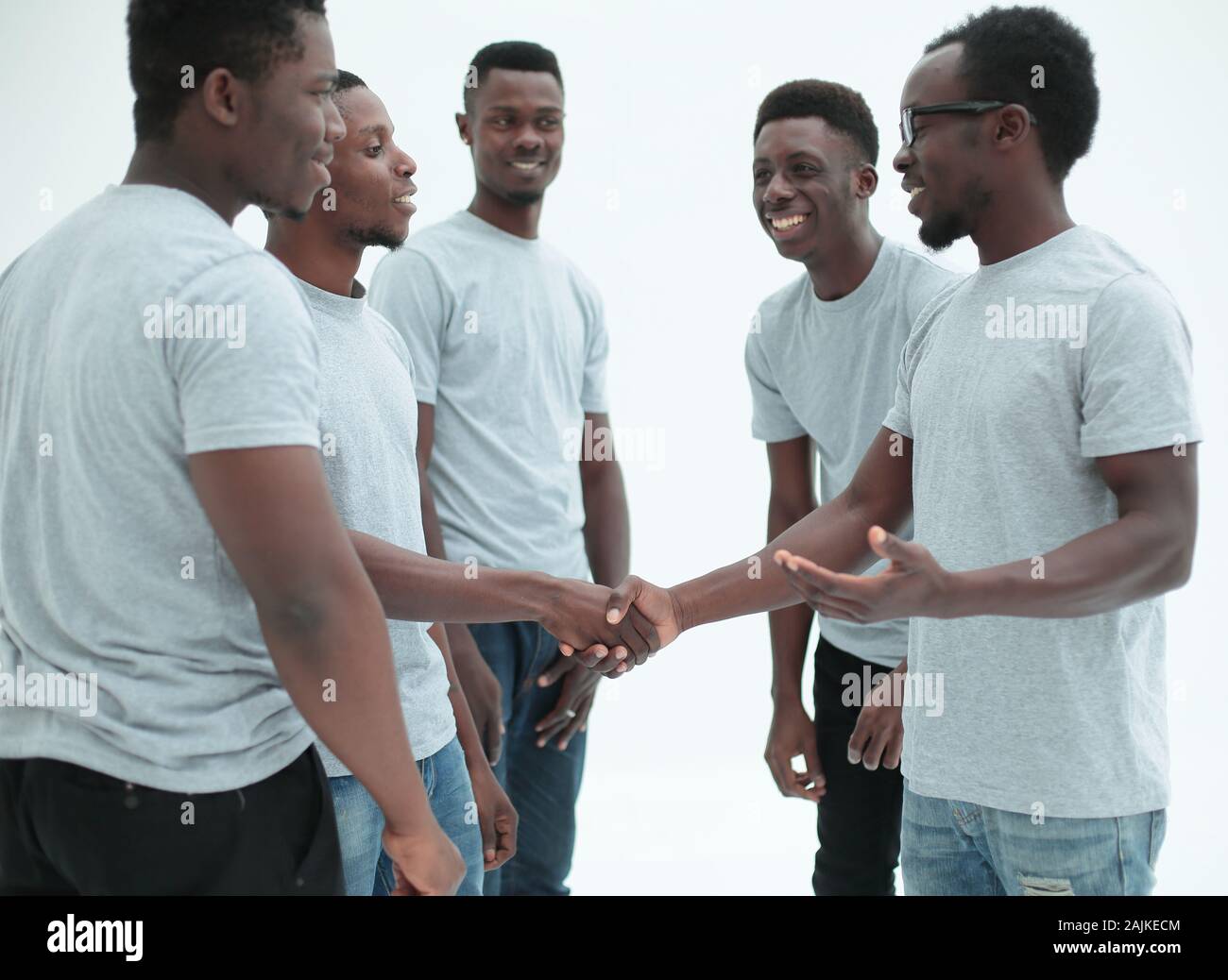 Junge Menschen die Hände schütteln, stehen in einem Kreis von Freunden Stockfoto