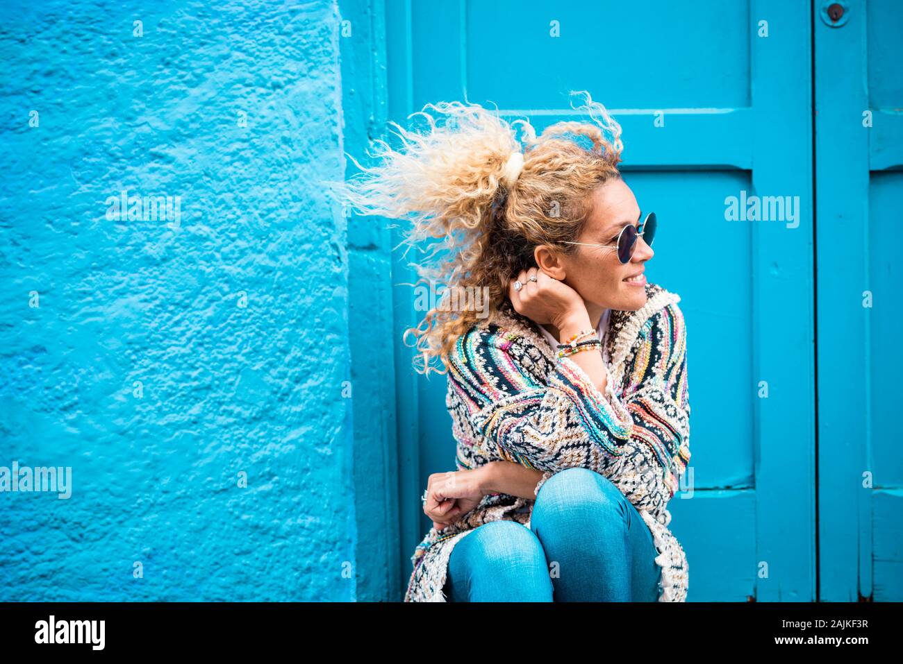 Farbige und trendigen Lifestyle Fashion Portrait von schönen jungen kaukasischen mittleren Alter Frau auf der Suche auf der linken Seite - Blau traditionelle alte Home backgrou Stockfoto