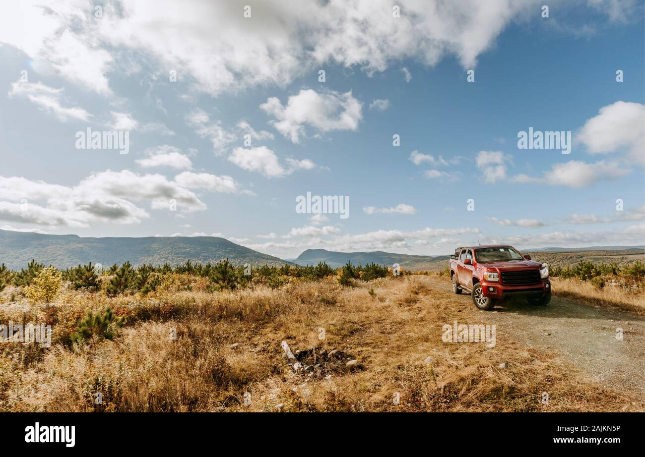 Roter Pickup-Truck neben Feuerring in einem clearcut, Greenville, Maine Stockfoto