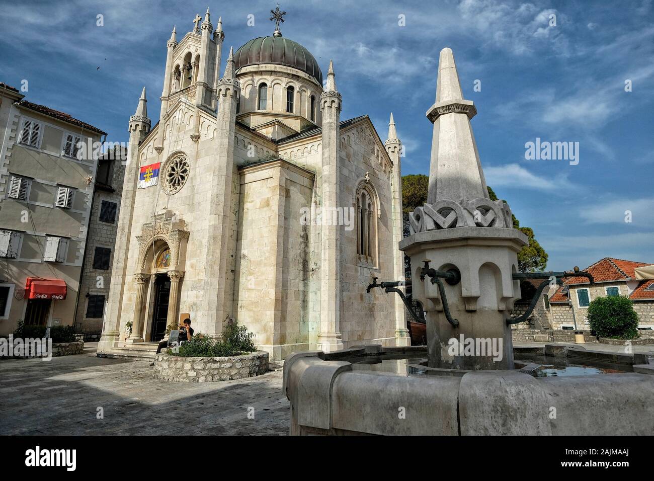 Herceg Novi, Montenegro - Juni 2019: Kirche des heiligen Michael Erzengels mit dem alten Steinbrunnen im Vordergrund am 22. Juni 2019 in Herceg Novi Stockfoto