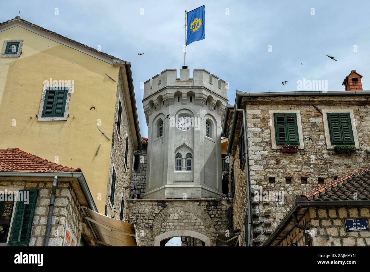Herceg Novi, Montenegro - Juni 2019: Altes Stadttor mit dem kleinen Uhrturm umgeben von alten Häusern am 22. Juni 2019 in Herceg Novi, Montenegro. Stockfoto