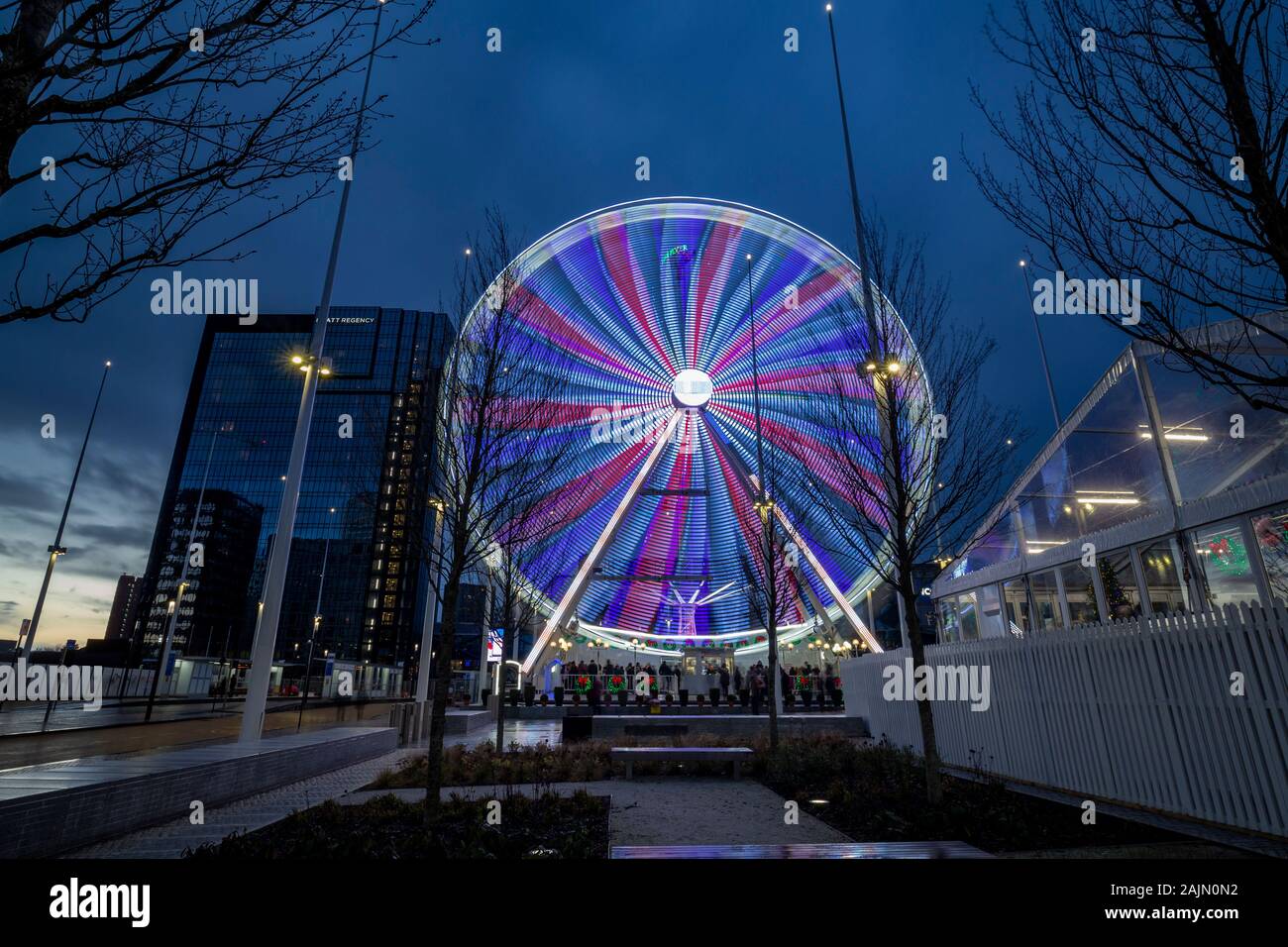 BIRMINGHAM, Großbritannien - 15 Dezember, 2019: Lange Belichtung Foto erfassen Union Jack geformte Lichter der großen Rad fahren in der Dämmerung Stockfoto