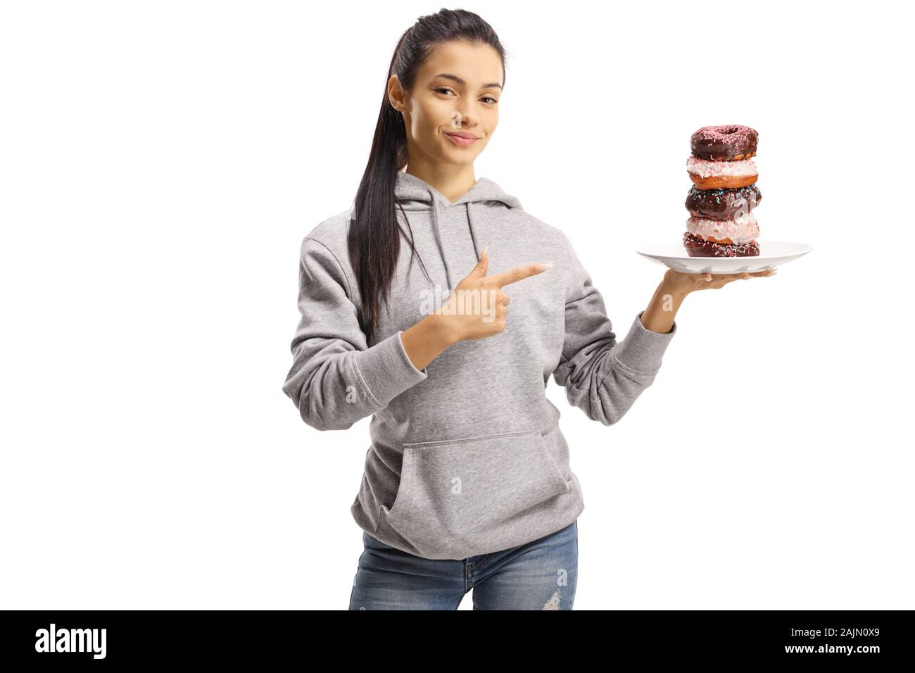 Junge weibliche Holding eine Platte mit Donuts und zeigt auf weißem Hintergrund Stockfoto