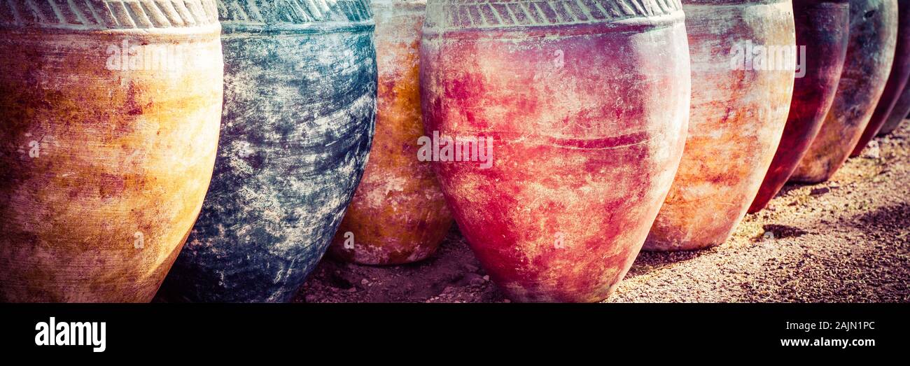 Ein Panoramaformat Nahaufnahme von primitiven Stil Tongefäße in sortierten Patina, mit einem Waschen von Farbe und handgemachten Designs in einer Wüstenumgebung Stockfoto
