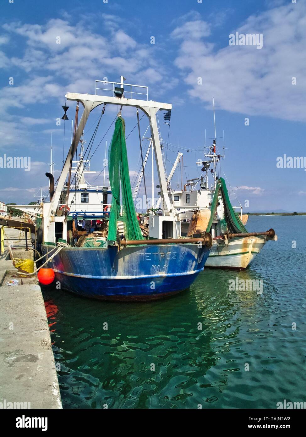 Thunfischwadenfänger angeln Schiffe mit Ausrüstung im Hafen von Porto Lagos unter blauem Himmel mit Wolken. Stockfoto