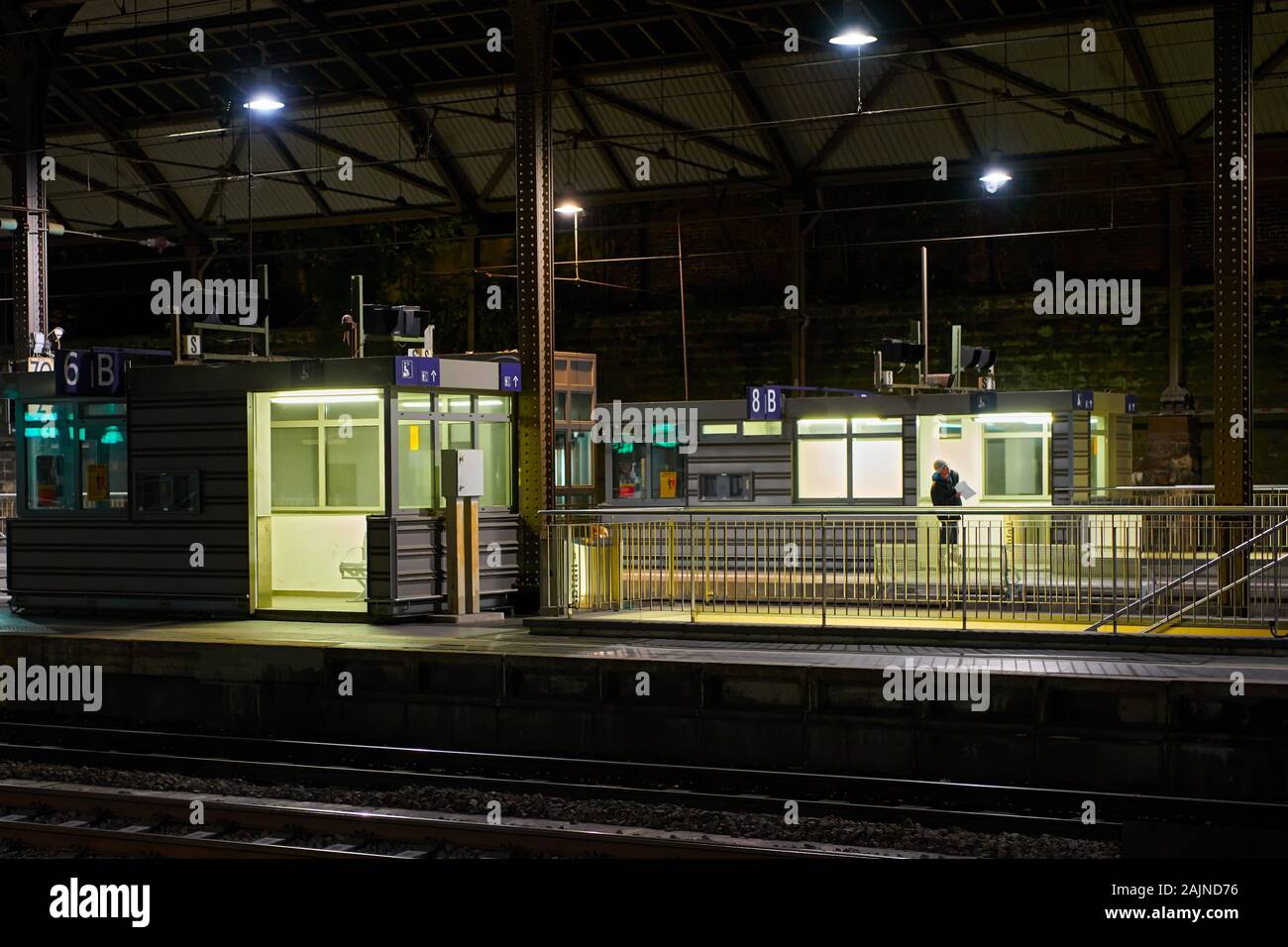 Aachen, Deutschland: Blick auf eine leere, saubere Plattform und Treppen am Hauptbahnhof in der Nacht mit künstlicher Beleuchtung Stockfoto