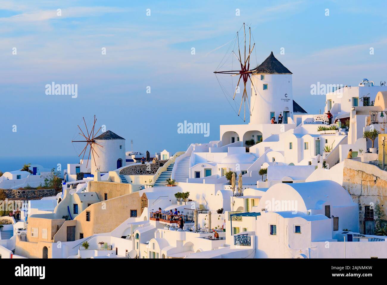 Windmühle und traditionelles weißes Gebäude mit Blick auf die Ägäis in Oia, Santorini, Griechenland Stockfoto