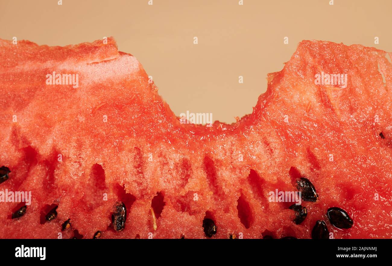 Makro Blick auf saftige Wassermelone Bissen auf Braun studio Hintergrund Stockfoto