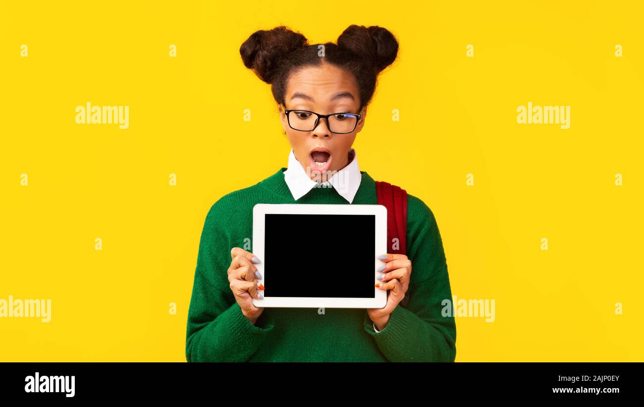 Awesome Anwendung oder Website. Schwarze Mädchen zeigt leeres Tablet Display für Werbung aufgeregt, Mock up, kopieren Raum Stockfoto