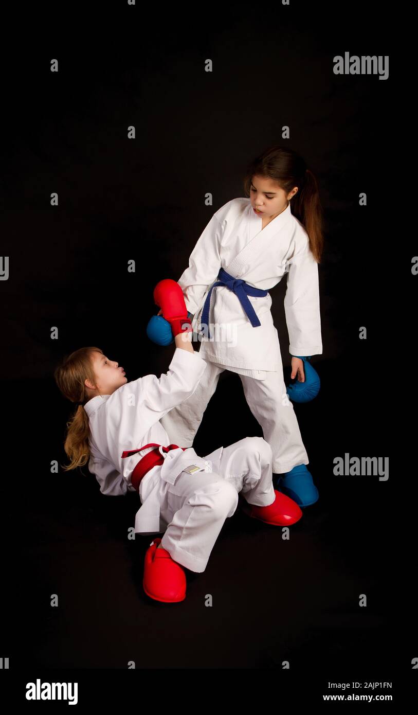 Karate Mädchen erweitert eine helfende Hand das zweite Mädchen nach einem erfolgreichen Angriff in der Ausbildung besiegt Stockfoto