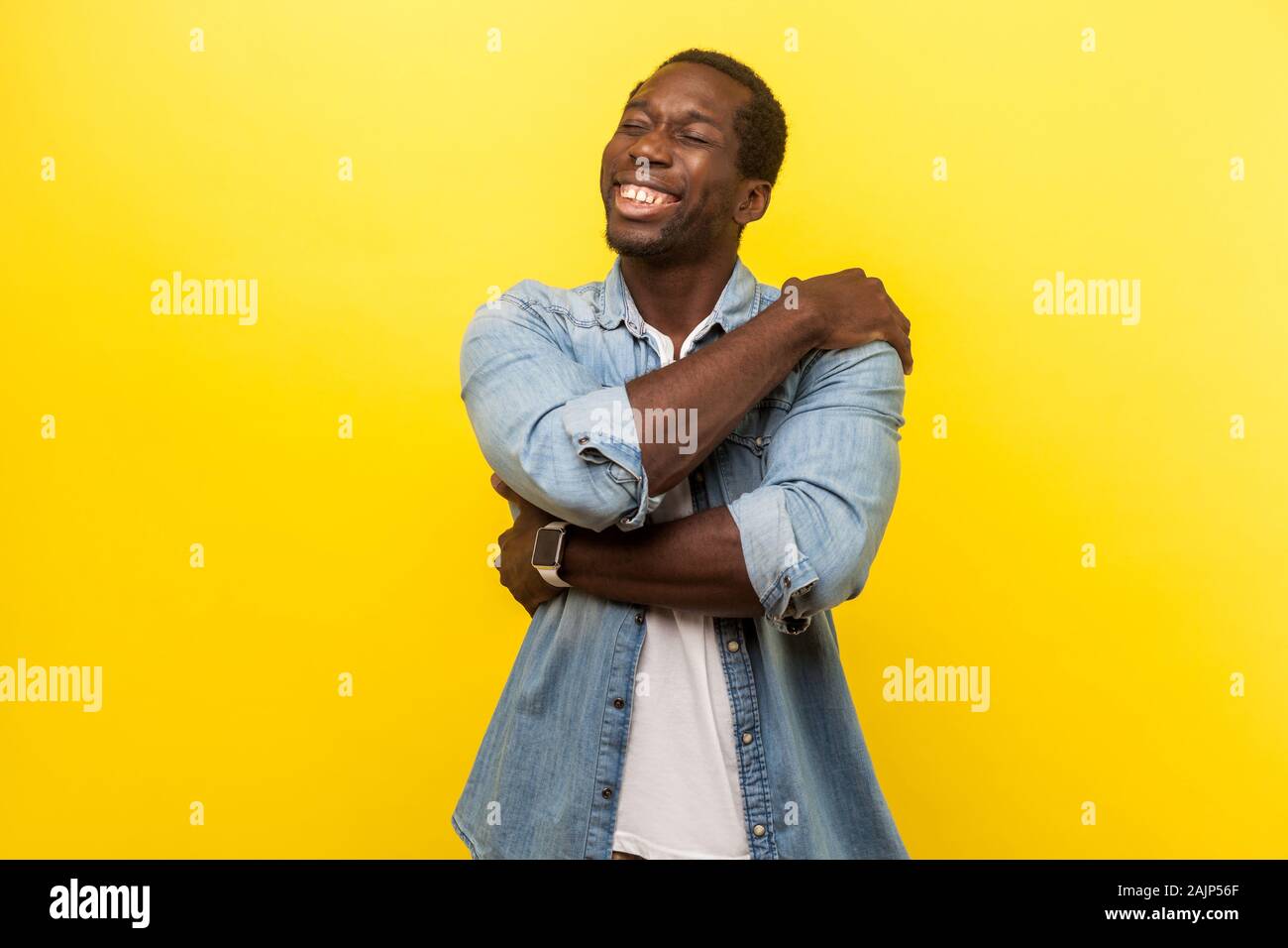 Ich liebe mich. Porträt der selbstzufriedenen glücklicher Mann in Jeans casual Shirt selbst Kuscheln und lächelnd mit Freude Freude Ausdruck, Egoist. indo Stockfoto