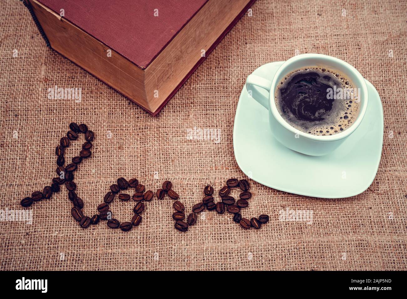 Ein vintage Bild zeigt die Liebe mit Kaffeebohnen und einer Tasse Kaffee Stockfoto