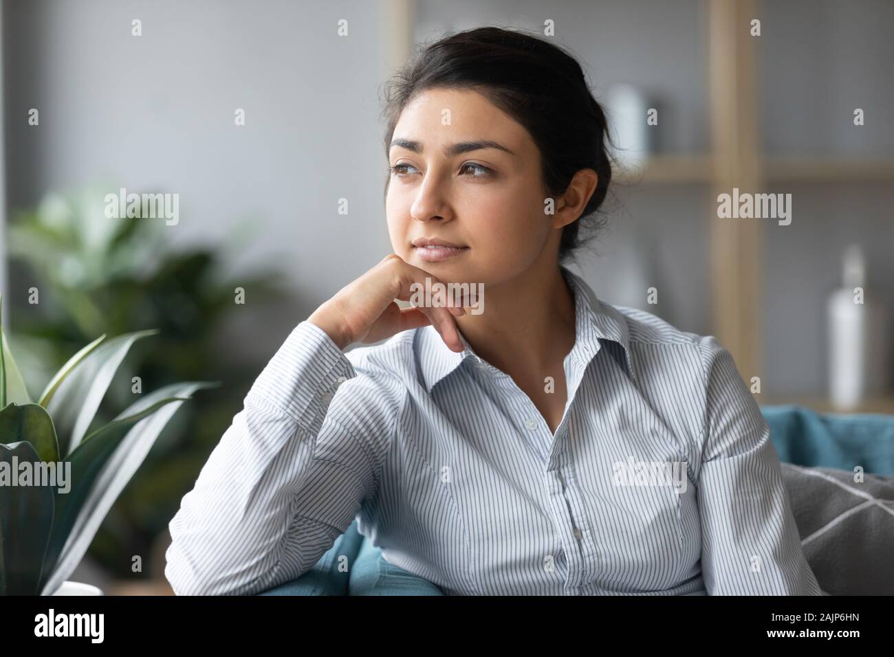 Serene indische Frau auf Sofa suchen Träumen der Zukunft Stockfoto