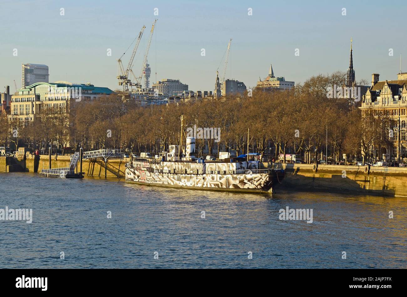 London, Großbritannien, 19. Januar 2016: kunstvoll bemalte Schiff HMS Präsident 1918 ehemalige HMS Aster auf der Themse mit verschiedenen Gebäuden und Cr Stockfoto
