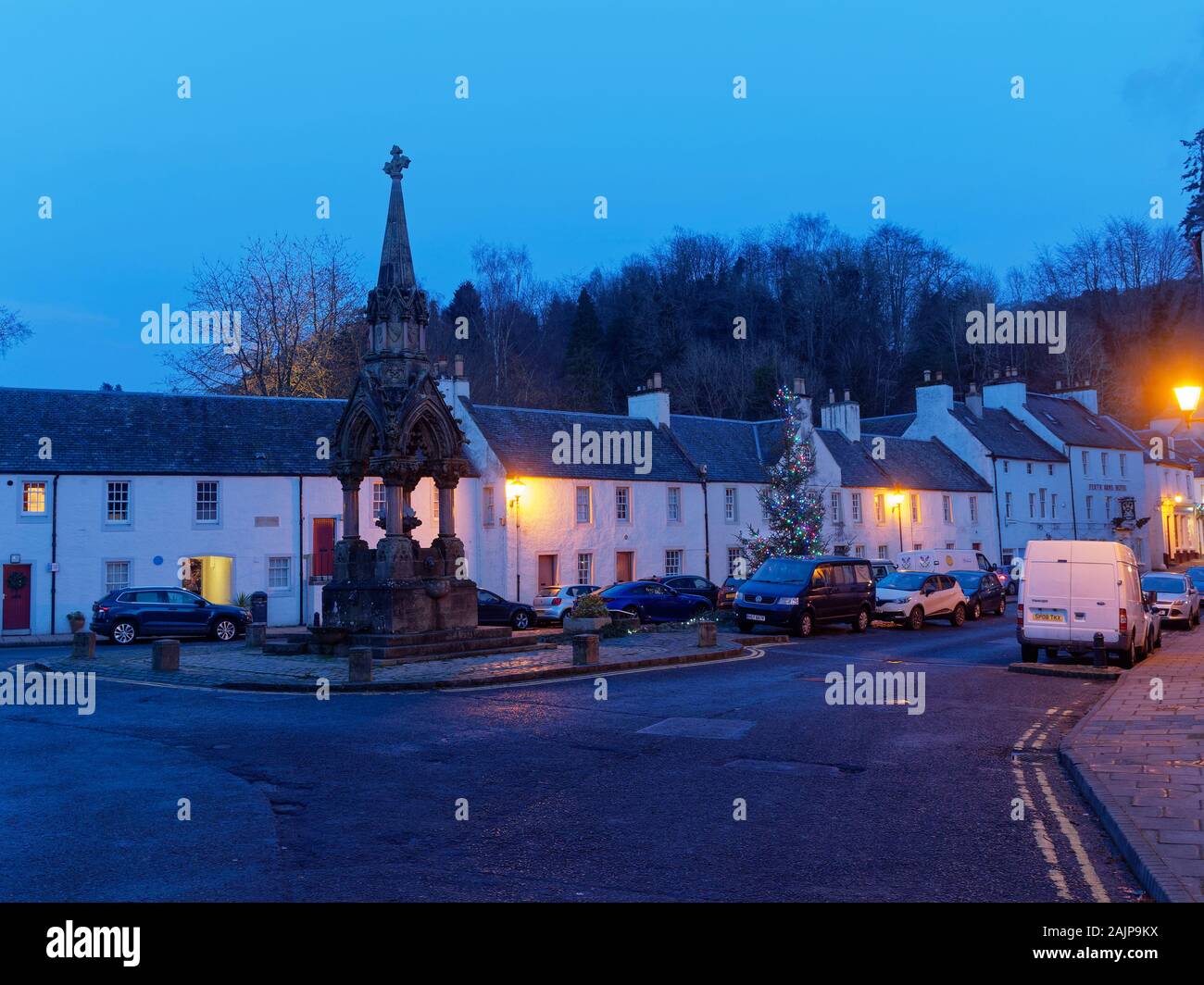 Den Blick von der High Street und das Kreuz von Dunkeld, mit der Atholl Memorial Fountain und beleuchtete Weihnachtsbaum am Tag der neuen Jahre Abend. Stockfoto