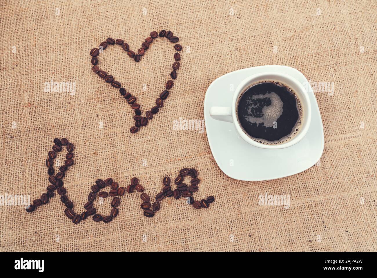 Ein vintage Bild zeigt die Liebe mit Kaffeebohnen und einer Tasse Kaffee Stockfoto