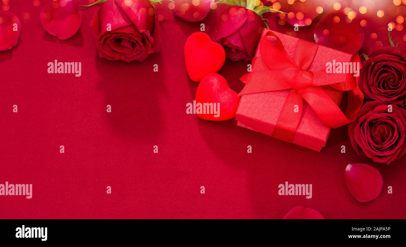 Valentinstag Geschenk. Rosen und roter Geschenkbox auf Stoff Textur Stockfoto