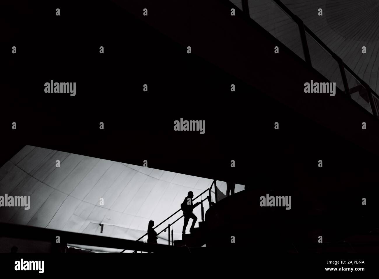 Silhouetten, die in einem Gebäude über Treppen und Stege. Stockfoto