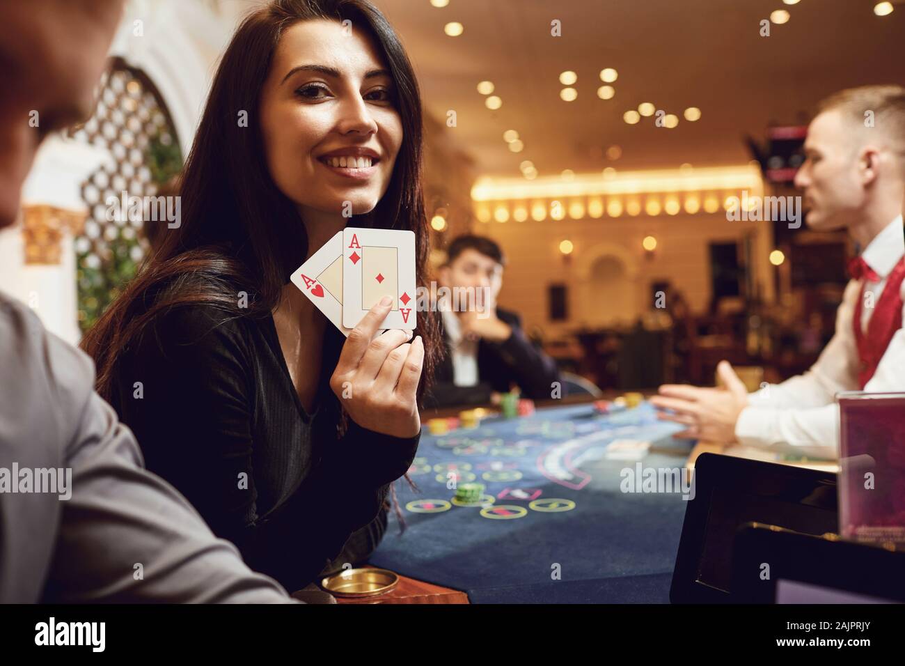 Mädchen mit Karten in ihren Händen lächelt Winning Poker in einem Casino. Stockfoto