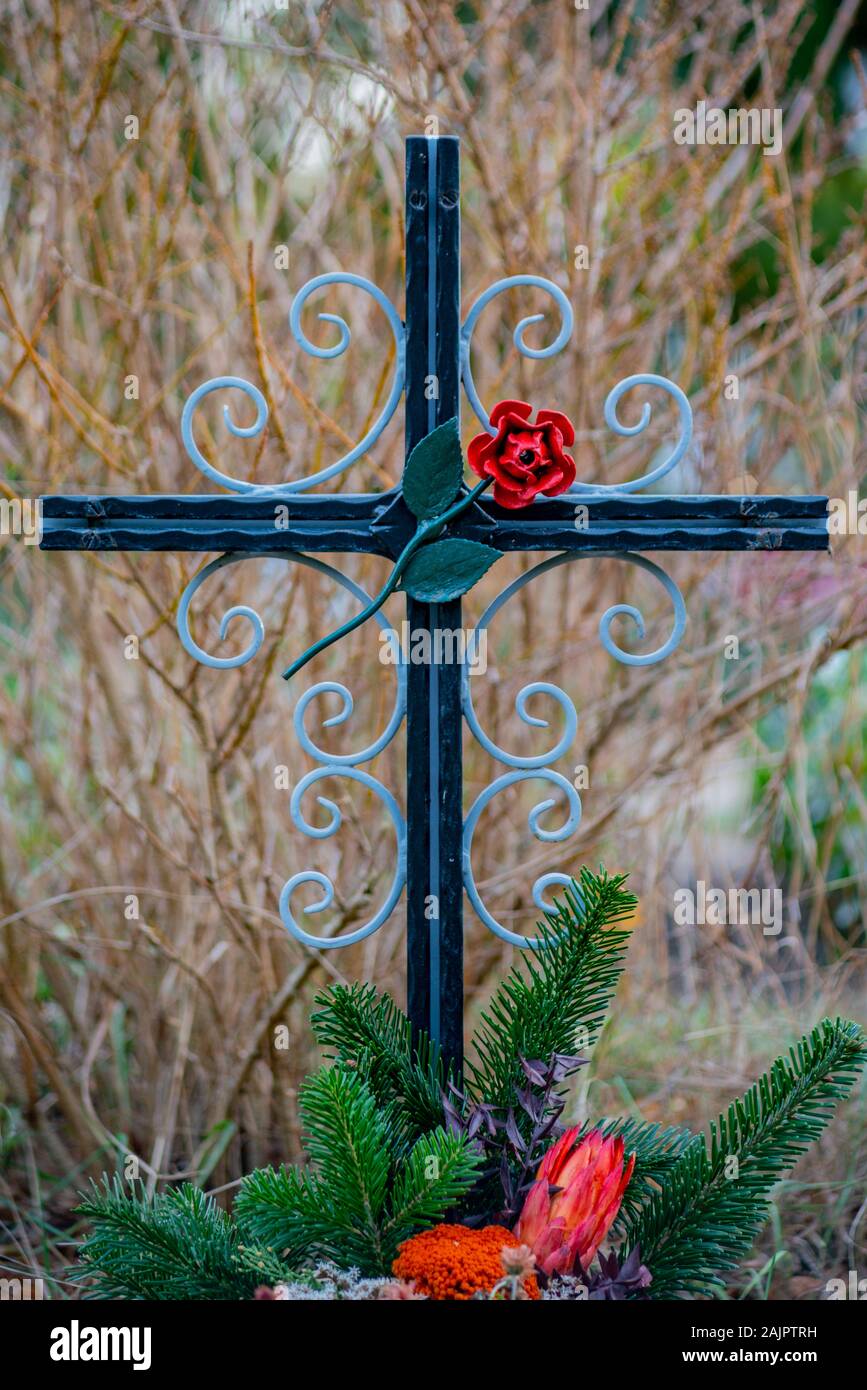 Friedhof Tegel, Berlin, Deutschland - 29 November 2018: Cast Iron Cross mit einer roten Rose auf einem Grab Stockfoto