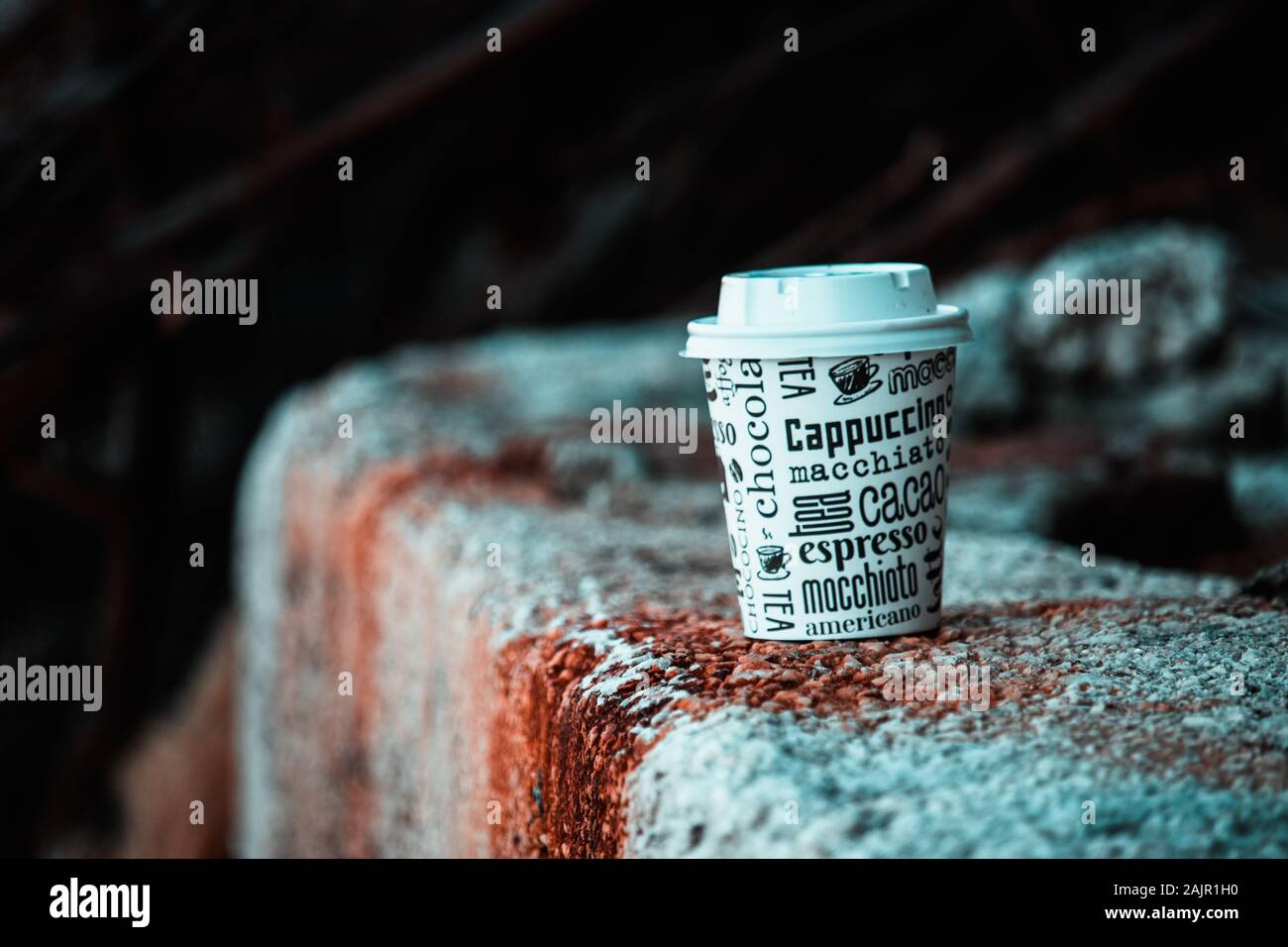 Papier Kaffee Tasse an einer Wand auf einem rostfleck. Generisches Design mit Namen von verschiedenen Kaffeesorten Stockfoto