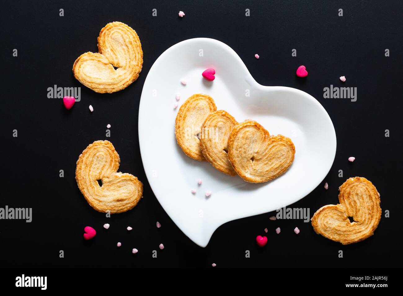 Valentine Dessert essen Konzept Blätterteig Herzen in weißer Keramik Herz Form auf schwarzen Hintergrund mit Kopie Raum Stockfoto