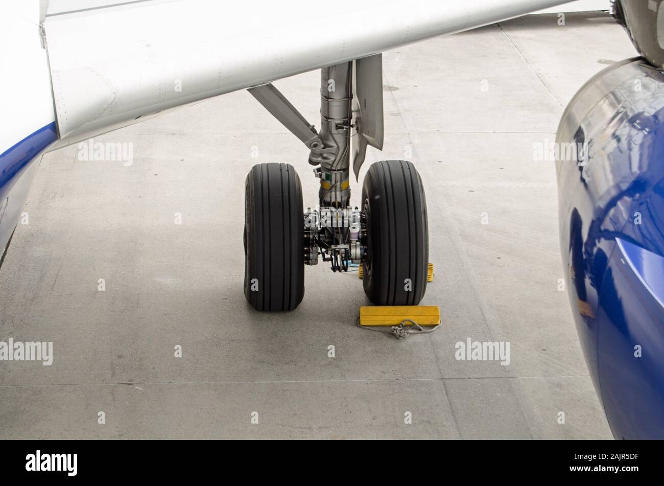 Keile um die Räder des Fahrwerks eines Airbus A319. Sie verhindern, dass das Flugzeug von Rollen in den Wind. Stockfoto