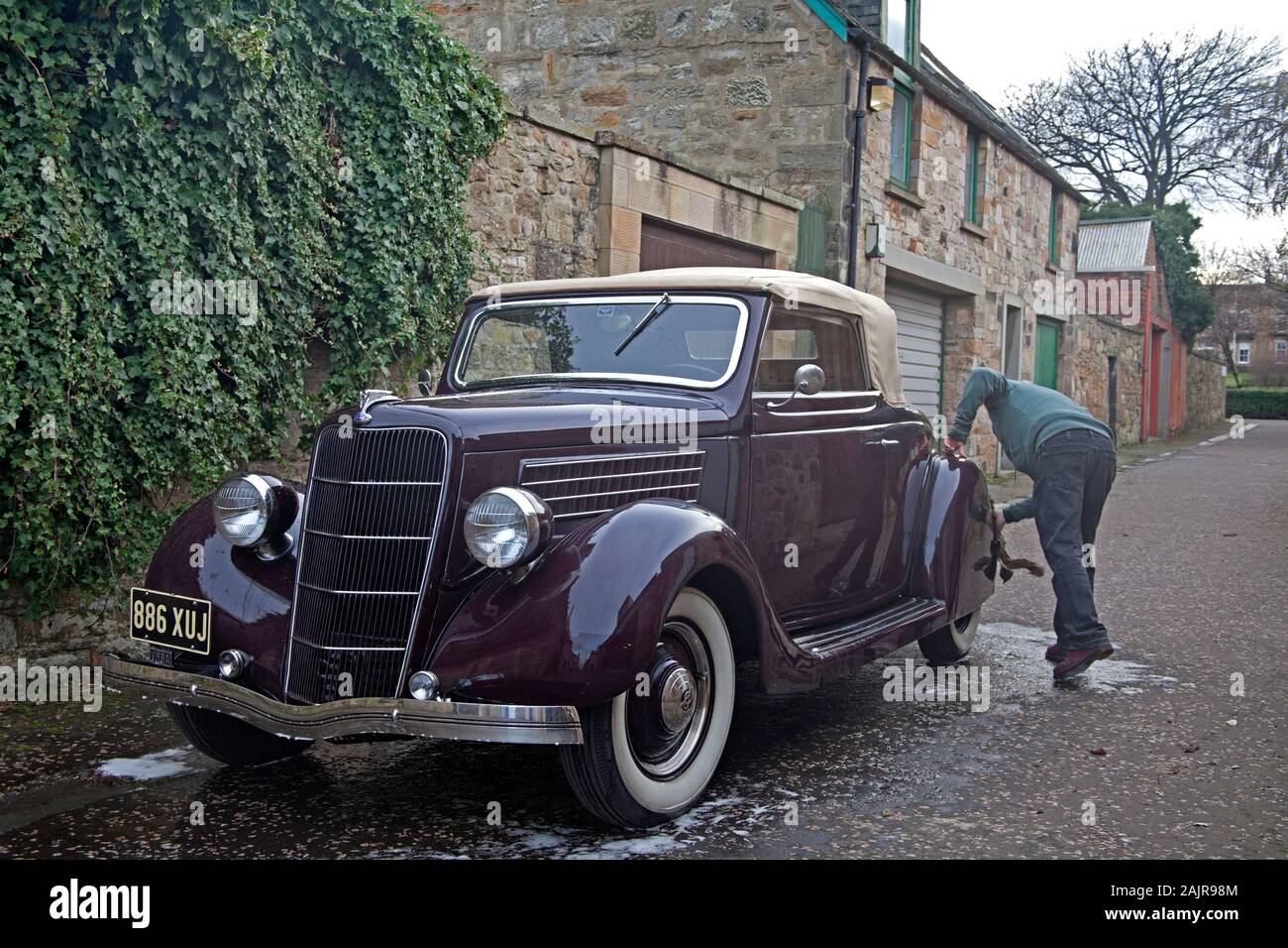 Portobello, Edinburgh, Schottland, Großbritannien. 5. Januar 2020. Gordon wäscht seine vintage Ford 1935 Cabrio Verdeck Fahrzeugs, das er für zwei Jahre besessen hat und ist nach wie vor die Wiederherstellung des Inneren. Er kaufte es nach nur sehen, ein Foto von dem Auto. Stockfoto