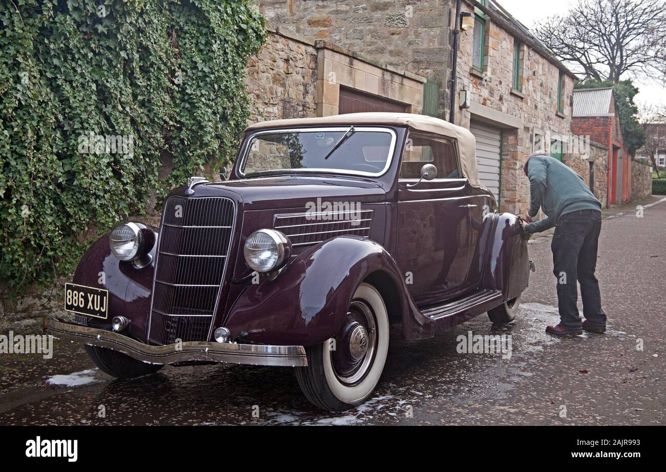 Portobello, Edinburgh, Schottland, Großbritannien. 5. Januar 2020. Gordon wäscht seine vintage Ford 1935 Cabrio Verdeck Fahrzeugs, das er für zwei Jahre besessen hat und ist nach wie vor die Wiederherstellung des Inneren. Er kaufte es nach nur sehen, ein Foto von dem Auto. Stockfoto