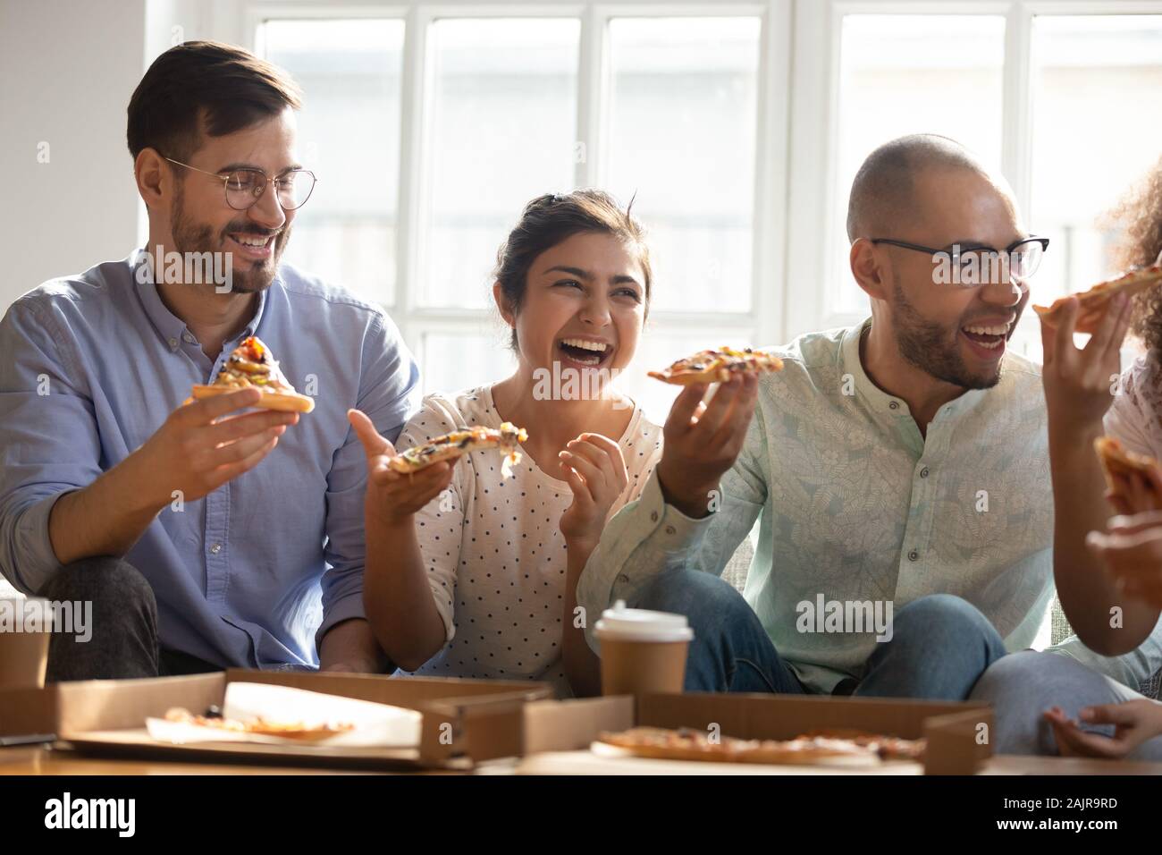 Happy multiethnischen tausendjährigen Freunde viel Spaß essen Pizza zusammen Stockfoto
